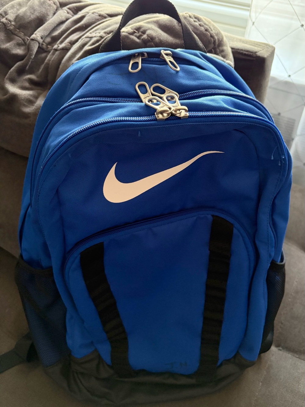 Nike Blue Backpack with White Swoosh initials are on it, but not noticeable